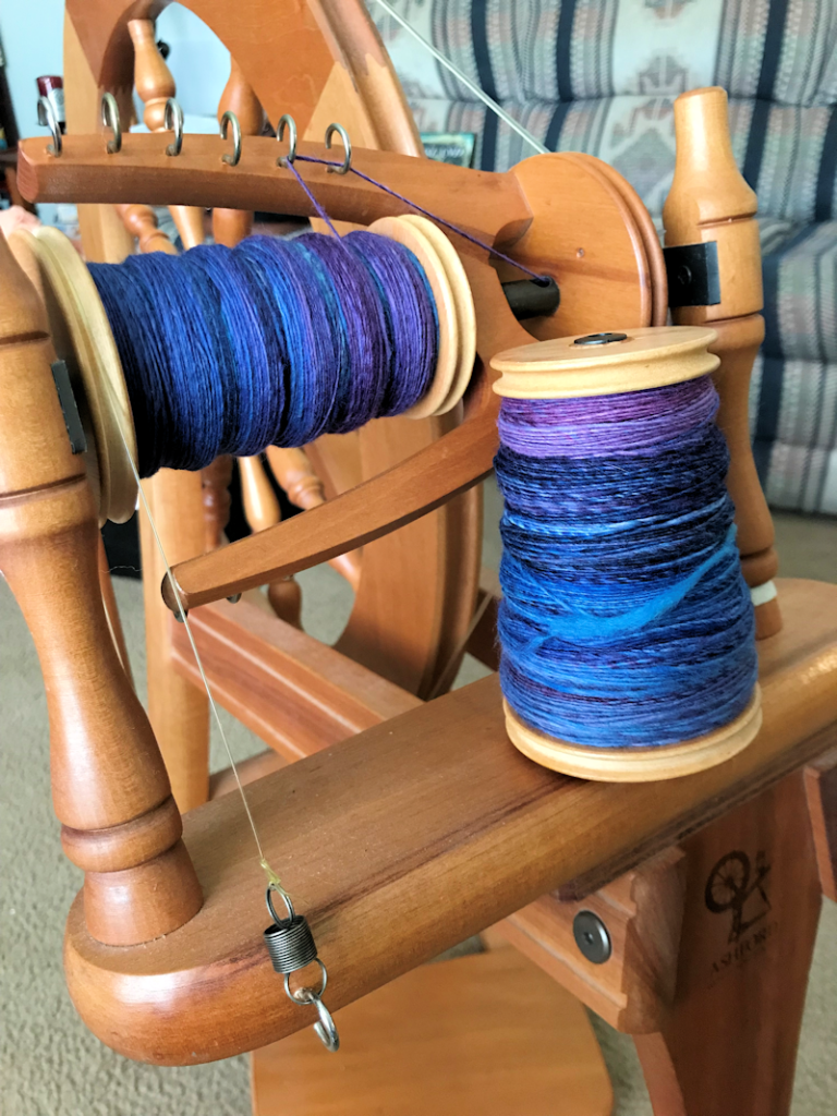 Full and partially completed bobbins of Malabrigo Nube in the "Whales Road" colorway, handspun by Lark. 